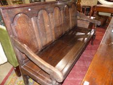 AN 18th.C.AND LATER OAK HALL SETTLE WITH FIVE PANEL BACK AND PLANK SEAT. W.183cms.