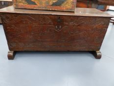 AN ANTIQUE OAK PLANK COFFER WITH NAIVE CARVED DECORATION OF MERMAIDS, DRAGONS, GRAPEVINE,ETC. W.