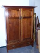 A LATE VICTORIAN/EDWARDIAN LIBERTY & Co ARTS AND CRAFTS WALNUT TWO DOOR WARDROBE WITH SPLAY CORNICE.