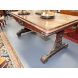 A CARVED ROSEWOOD VICTORIAN LIBRARY TABLE WITH SHAPED TRESTLE ENDS AND SCROLL DECORATION. H.72 x W.