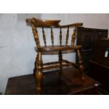 AN ANTIQUE BEECH AND ELM CAPTAIN'S CHAIR ON STOUT TURNED LEGS.