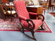 A MAHOGANY VICTORIAN ROCKING CHAIR WITH SCROLL BACK AND ARMS.