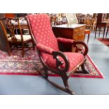 A MAHOGANY VICTORIAN ROCKING CHAIR WITH SCROLL BACK AND ARMS.