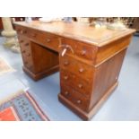 AN OAK VICTORIAN TWIN PEDESTAL DESK WITH TOOLED INSET BROWN LEATHER AND THREE APRON DRAWERS ABOVE
