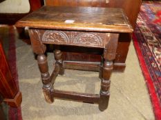 AN ANTIQUE OAK JOINT STOOL WITH CARVED FRIEZE. W.46cms.