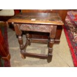 AN ANTIQUE OAK JOINT STOOL WITH CARVED FRIEZE. W.46cms.