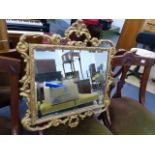 A GILT FRAMED WALL MIRROR.