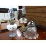 TWO OIL LAMPS AND A PAIR OF HANGING LIGHT SHADES.