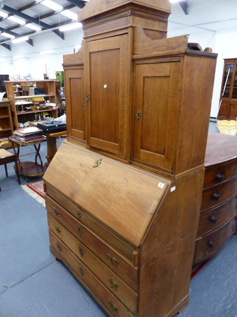 A CONTINENTAL OAK BUREAU BOOKCASE WITH FITTED INTERIOR.