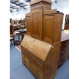 A CONTINENTAL OAK BUREAU BOOKCASE WITH FITTED INTERIOR.