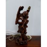 AN ORIENTAL CARVED FRUITWOOD TABLE LAMP.