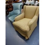 AN EDWARDIAN WING BACK ARMCHAIR ON SQUARE LEGS AND A MODERN ARMCHAIR.