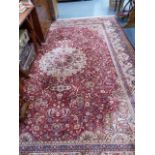 A LARGE RED GROUND PERSIAN PATTERN CARPET.