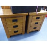 A PAIR OF OAK THREE DRAWER BEDSIDE CHESTS.