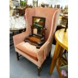AN ANTIQUE WING BACK ARMCHAIR.