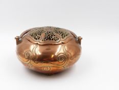 A FINELY CHASED AND CAST COPPER ORIENTAL COVERED CENSOR OR HAND WARMER WITH SWING HANDLE ON SHORT