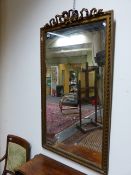 AN ANTIQUE GILT FRAMED PIER MIRROR WITH RIBBON PEDIMENT. 75 x 146cms.