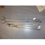 THREE LARGE WROUGHT IRON FIRESIDE LOG POKERS AND A SET OF LOG TONGS. LARGEST L.120cms.