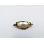 A MOTHER OF PEARL BROOCH SET IN PRECIOUS YELLOW METAL. APPROXIMATE WIDTH 3.5cms.