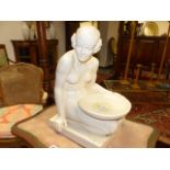 AN EARLY 20th.C.GLAZED CONTINENTAL FIGURE OF A SEATED LADY HOLDING A BOWL. IMPRESSED MARKS. H.