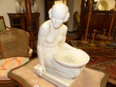 AN EARLY 20th.C.GLAZED CONTINENTAL FIGURE OF A SEATED LADY HOLDING A BOWL. IMPRESSED MARKS. H.