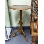 AN INTERESTING BLACK FOREST OR GROTTO TYPE TRIPOD TABLE WITH CARVED BASE AND LEAF DECORATION TO TOP.