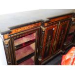 A VICTORIAN AESTHETIC EBONISED AND INLAID LOW BOOKCASE WITH TWO GLAZED AND TWO PANEL DOORS. W.184