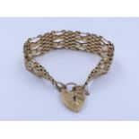 A 9ct GOLD SIX BAR GATE BRACELET COMPLETE WITH SAFETY CHAIN AND PADLOCK. APPROXIMATE WEIGHT 26grms.