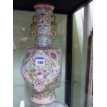 A CHINESE FAMILLE ROSE TWIN HANDLED VASE OF UNUSUAL GEOMETRIC FORM WITH OVERALL FLORAL DECORATION ON