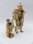 TWO JAPANESE CARVED IVORY FIGURES, A STANDING FIGURE OF A STREET VENDOR (H.15.5cms) AND A SMALLER