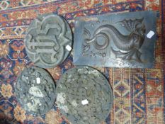 THREE CARVED STONE ROUNDELS AND A REPOUSSE PANEL OF A FISH.