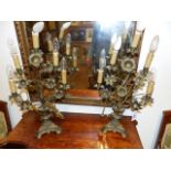 A PAIR OF ANTIQUE FRENCH BRASS TABLE CANDELABRA WITH STYLISED FLOWER HEAD DECORATION FITTED AS