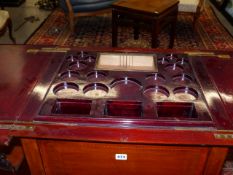 AN EDWARDIAN MAHOGANY DRINKS CABINET WITH FOLD OVER TOP AND RISING CENTRE BOTTLE SUPPORT.