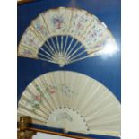 TWO ANTIQUE CARVED AND PAINTED FANS MOUNTED IN A BESPOKE SHADOW B OX FRAME EACH WITH PIERCED WORK