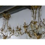 AN IMPRESSIVE PAIR OF GILT BRASS CAGE CHANDELIERS HUNG WITH LARGE CUT GLASS AND FACET DROPS. H.