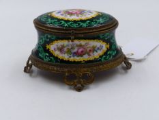 A VICTORIAN FRENCH ENAMEL OVAL DRESSER BOX WITH PIERCED BRASS MOUNTS AND POLYCHROME FLORAL SPRAYS ON