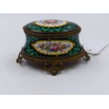 A VICTORIAN FRENCH ENAMEL OVAL DRESSER BOX WITH PIERCED BRASS MOUNTS AND POLYCHROME FLORAL SPRAYS ON