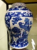 AN ORIENTAL BLUE AND WHITE BALUSTER VASE DECORATED WITH PANELS OF BIRDS FRAMED BY FOLIATE MOTIFS.