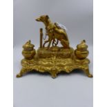A VICTORIAN STYLE SPELTER AND GILT DECORATED DESK STAND SURMOUNTED WITH A FIGURE OF A SPORTING DOG.