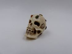 A FINELY CARVED AND INLAID JAPANESE OKIMONO OF A HUMAN SKULL WITH OVERALL DECORATION OF