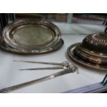 A SMALL SILVER PLATED MEAT COVER, THREE SERVING TRAYS AND FOUR SKEWERS.