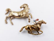 A 9ct GOLD HORSE BROOCH TOGETHER WITH A FURTHER 9ct GOLD HORSE BROOCH WITH ENAMEL JOCKEY.