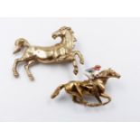 A 9ct GOLD HORSE BROOCH TOGETHER WITH A FURTHER 9ct GOLD HORSE BROOCH WITH ENAMEL JOCKEY.