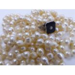 A ROPE STRAND OF KNOTTED BAROQUE PEARLS, APPROXIMATE LENGTH 184cms, TOGETHER WITH A PRECIOUS
