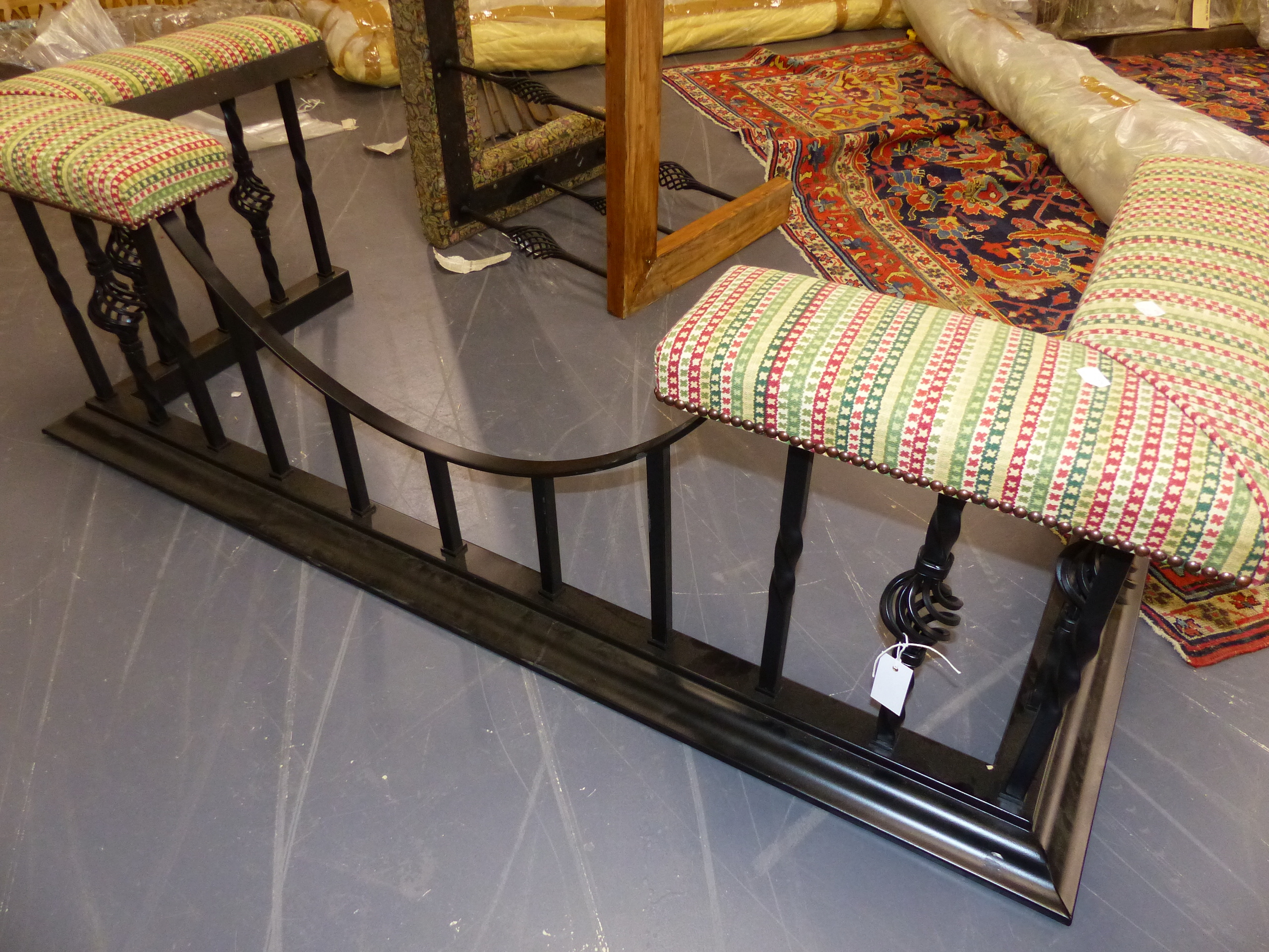 A LARGE WROUGHT IRON CLUB FENDER WITH UPHOLSTERED ENDS AND DROP CENTRE. W.165cms.