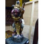 A CARVED AND DECORATED INDONESIAN FIGURE OF A MYTHICAL WARRIOR HOLDING A SWORD. H.61cms.