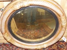 AN ANTIQUE GILT FRAMED CONVEX WALL MIRROR. D.65cms.