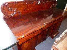 AN EARLY VICTORIAN MAHOGANY SIDEBOARD WITH RAISED CARVED PANEL BACK OVER DRAWERS AND FOUR DOORS ON