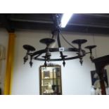 A WROUGHT IRON CHANDELIER WITH EIGHT CANDLE HOLDERS.