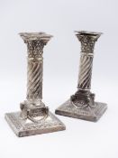 A PAIR OF VICTORIAN SILVER COLUMN CANDLESTICKS ORNATELY DECORATED WITH A RAM'S HEAD AND SWAG DESIGN.